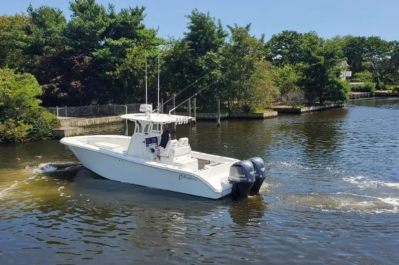 Salty Dog 2 Yacht Photos Pics 2013 Yellowfin 32 boat cruising on a calm river, surrounded by lush greenery.