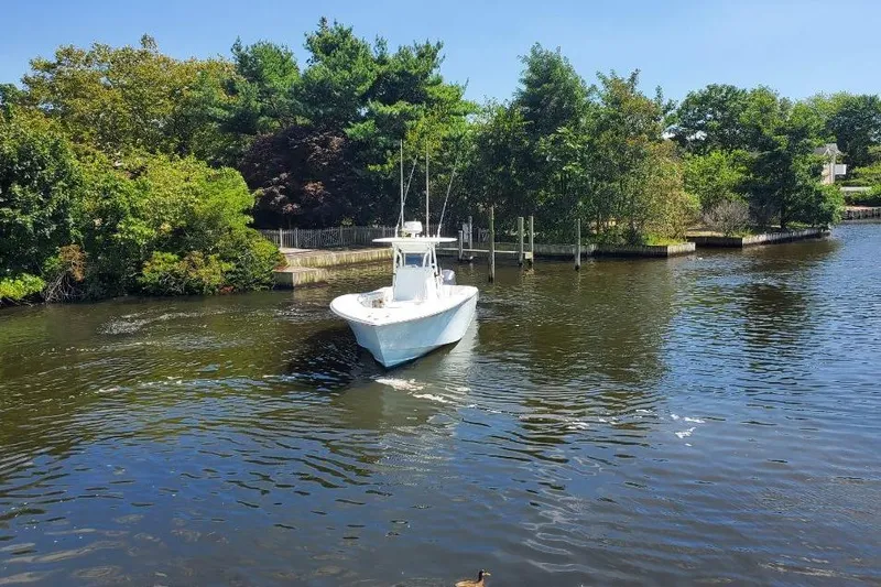 Salty Dog 2 Yacht Photos Pics 2013 Yellowfin 32 boat cruising on a serene river surrounded by lush greenery.