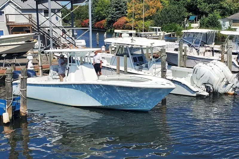 Salty Dog 2 Yacht Photos Pics 2013 Yellowfin 32 boat docked at marina with people onboard, surrounded by other boats.