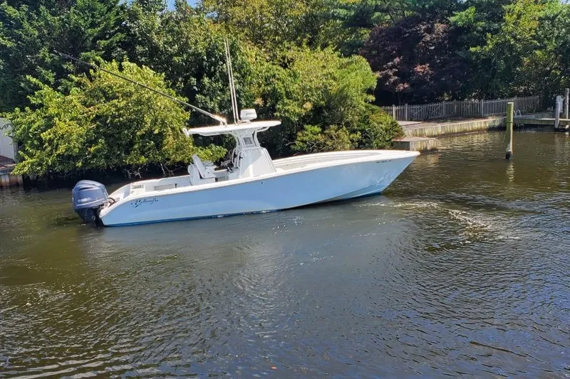Salty Dog 2 Yacht Photos Pics 2013 Yellowfin 32 boat on a calm river, surrounded by lush greenery.