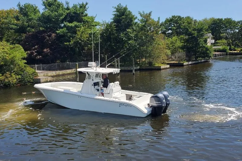 Salty Dog 2 Yacht Photos Pics 2013 Yellowfin 32 boat cruising on a scenic waterway surrounded by lush greenery.