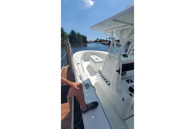 Salty Dog 2 Yacht Photos Pics 2013 Yellowfin 32 boat docked by a serene waterfront.