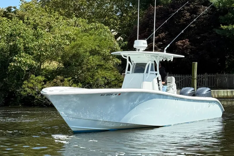 Salty Dog 2 Yacht Photos Pics 2013 Yellowfin 32 boat on calm water, surrounded by lush greenery.