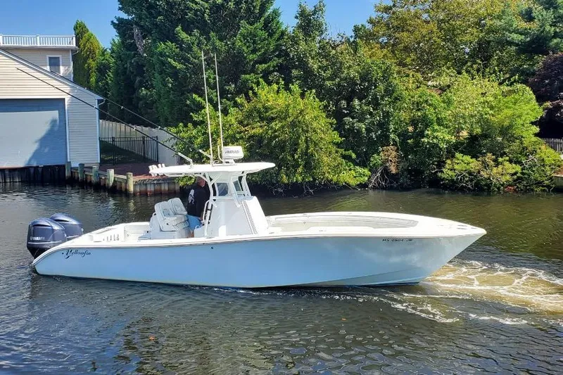 Salty Dog 2 Yacht Photos Pics 2013 Yellowfin 32 boat cruising on a calm river near lush greenery.