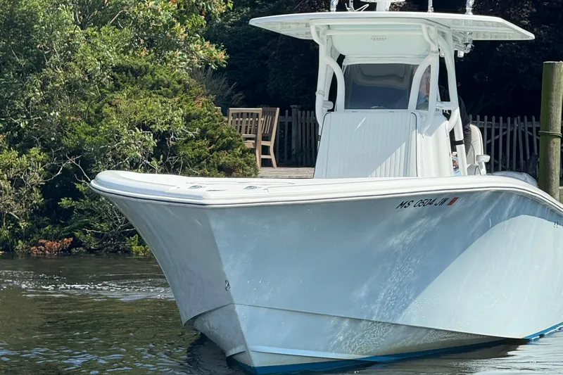 Salty Dog 2 Yacht Photos Pics 2013 Yellowfin 32 boat on calm water near lush greenery.