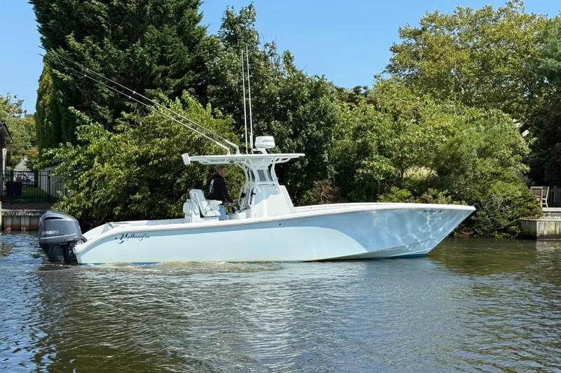 Salty Dog 2 Yacht Photos Pics 2013 Yellowfin 32 boat cruising on a calm river, surrounded by lush greenery.
