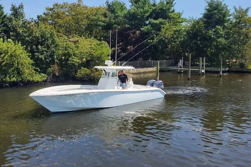 Salty Dog 2 Yacht Photos Pics 2013 Yellowfin 32 boat cruising on a calm river near lush green trees.