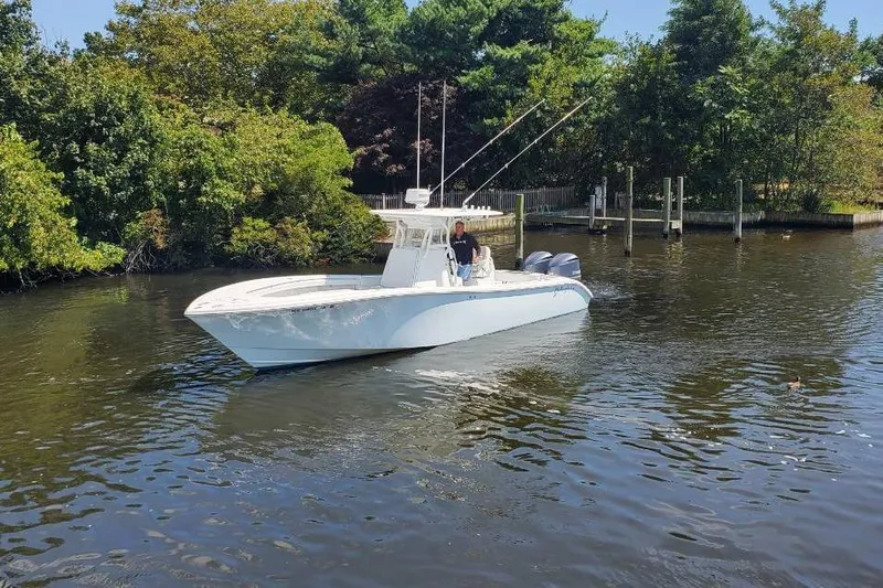 Salty Dog 2 Yacht Photos Pics 2013 Yellowfin 32 boat cruising on a calm river, surrounded by lush greenery.