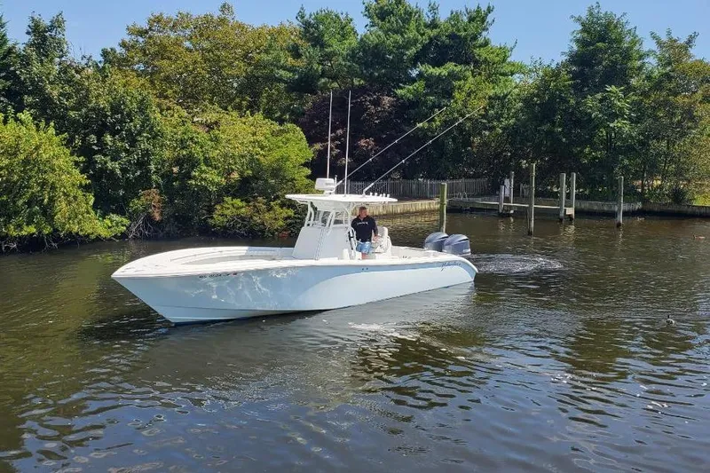 Salty Dog 2 Yacht Photos Pics 2013 Yellowfin 32 boat cruising on a calm river near lush greenery.
