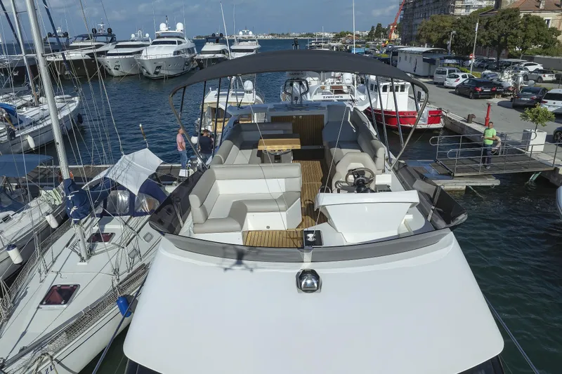 Neo Yacht Photos Pics 2022 Beneteau Monte Carlo 52 yacht docked at a marina, showcasing spacious deck and seating.