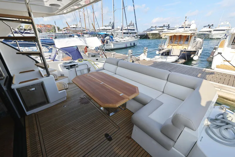 Neo Yacht Photos Pics Luxurious 2022 Beneteau Monte Carlo 52 yacht with spacious deck seating and elegant wooden table.