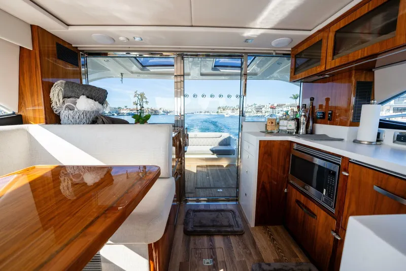 Ventures64 Yacht Photos Pics Luxurious interior of 2022 Riviera 4800 Sport Yacht with modern kitchen and scenic view.