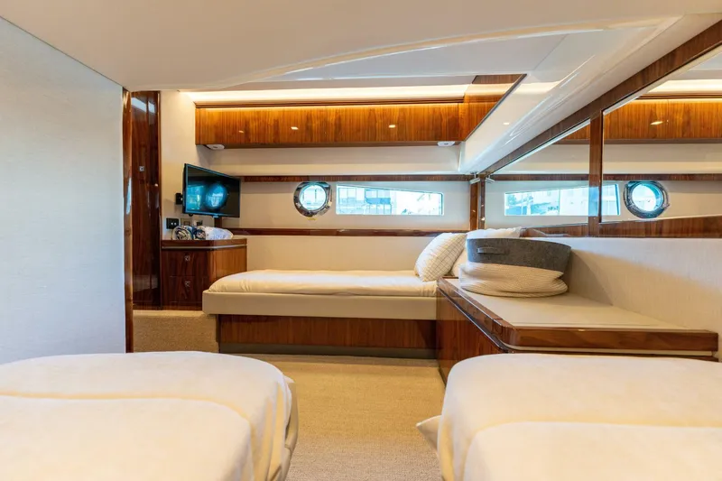 Ventures64 Yacht Photos Pics Luxurious interior of 2022 Riviera 4800 Sport Yacht with elegant wood finishes and cozy seating.
