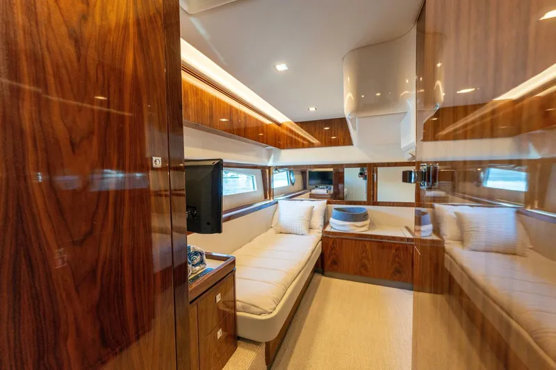 Ventures64 Yacht Photos Pics Luxurious interior of 2022 Riviera 4800 Sport Yacht with wood paneling and cozy seating.