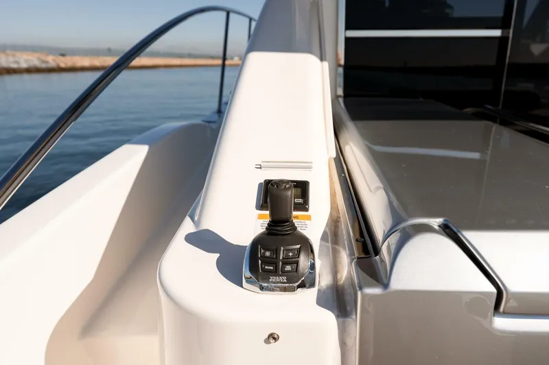 Ventures64 Yacht Photos Pics Riviera 4800 Sport Yacht 2022 joystick control on deck, overlooking calm waters.