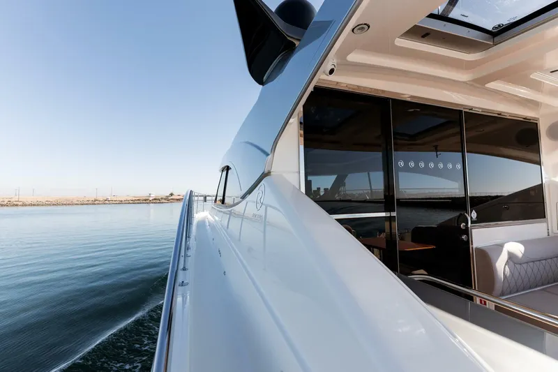 Ventures64 Yacht Photos Pics 2022 Riviera 4800 Sport Yacht cruising on calm waters, showcasing sleek design and luxurious interior.