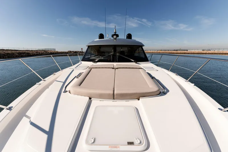 Ventures64 Yacht Photos Pics 2022 Riviera 4800 Sport Yacht on calm water, showcasing sleek deck design.