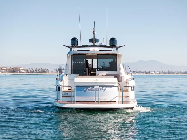 Ventures64 Yacht Photos Pics 2022 Riviera 4800 Sport Yacht cruising on calm waters, scenic coastal backdrop.