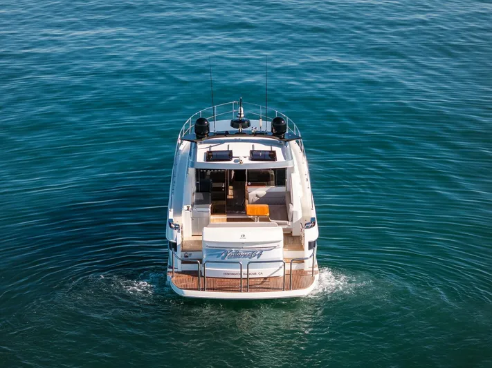 Ventures64 Yacht Photos Pics 2022 Riviera 4800 Sport Yacht cruising on open water, rear view.