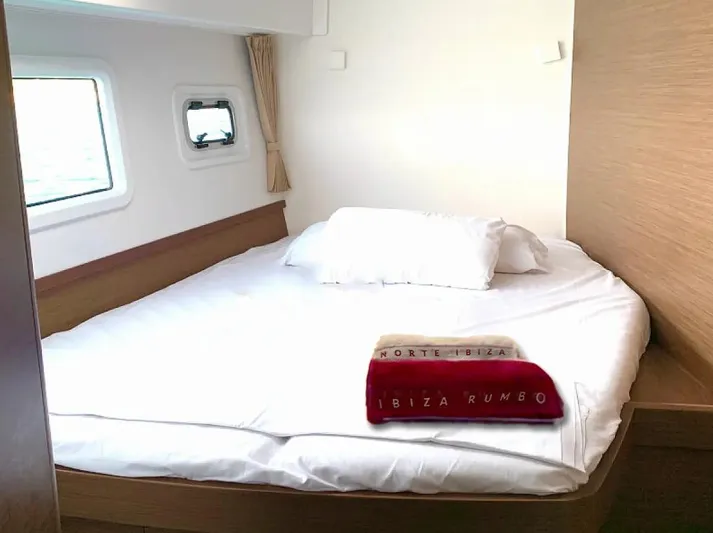  Yacht Photos Pics Cozy bedroom in 2024 Lagoon 42 yacht with white bedding and wooden accents.