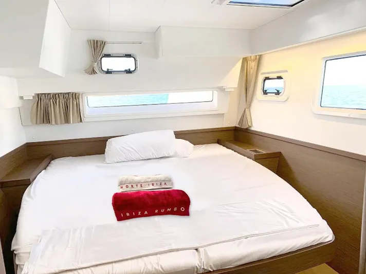  Yacht Photos Pics Luxurious cabin interior of 2024 Lagoon 42 yacht with large bed and ocean view.