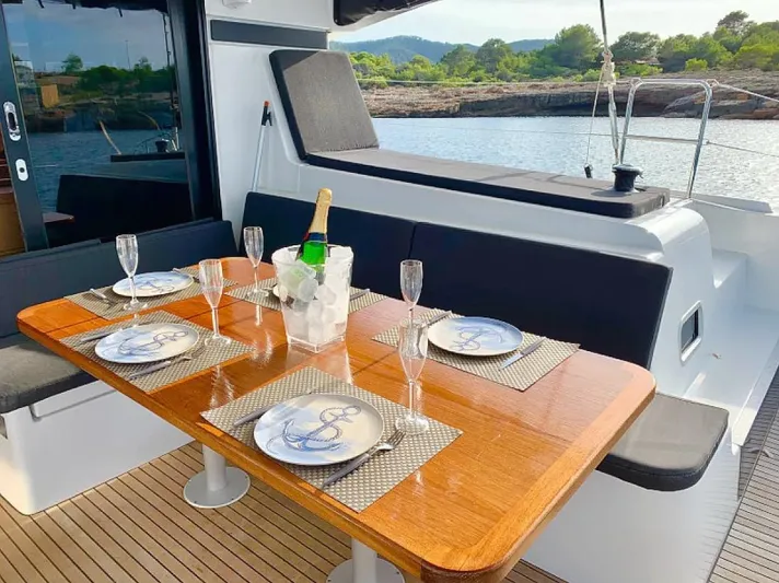  Yacht Photos Pics Luxurious dining setup on a 2024 Lagoon 42 yacht, featuring elegant tableware and champagne.