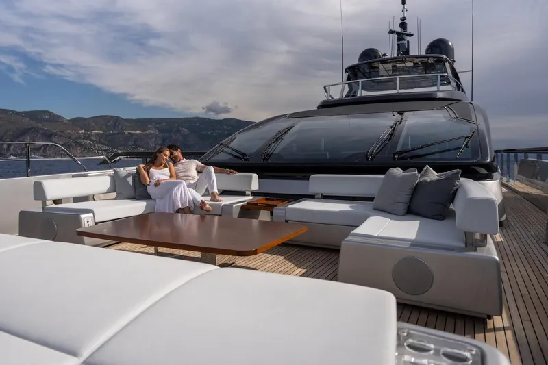 Tasty Waves Yacht Photos Pics Couple relaxing on luxurious 2025 Riva 130' Bellissima yacht deck with scenic ocean view.