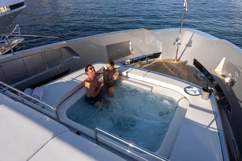 Tasty Waves Yacht Photos Pics Couple enjoying jacuzzi on 2025 Riva 130' Bellissima yacht, ocean view.