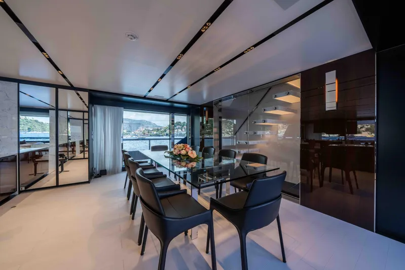 Tasty Waves Yacht Photos Pics Luxurious dining area on 2025 Riva 130' Bellissima yacht with elegant glass table and scenic views.