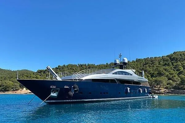 Lucky Me Yacht Photos Pics Luxurious 2010 Baglietto 41 yacht anchored in serene blue waters, surrounded by lush greenery.