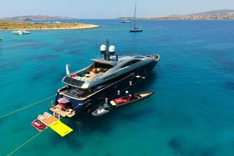 Lucky Me Yacht Photos Pics Luxurious 2010 Baglietto 41 yacht anchored in clear blue waters, surrounded by smaller boats.