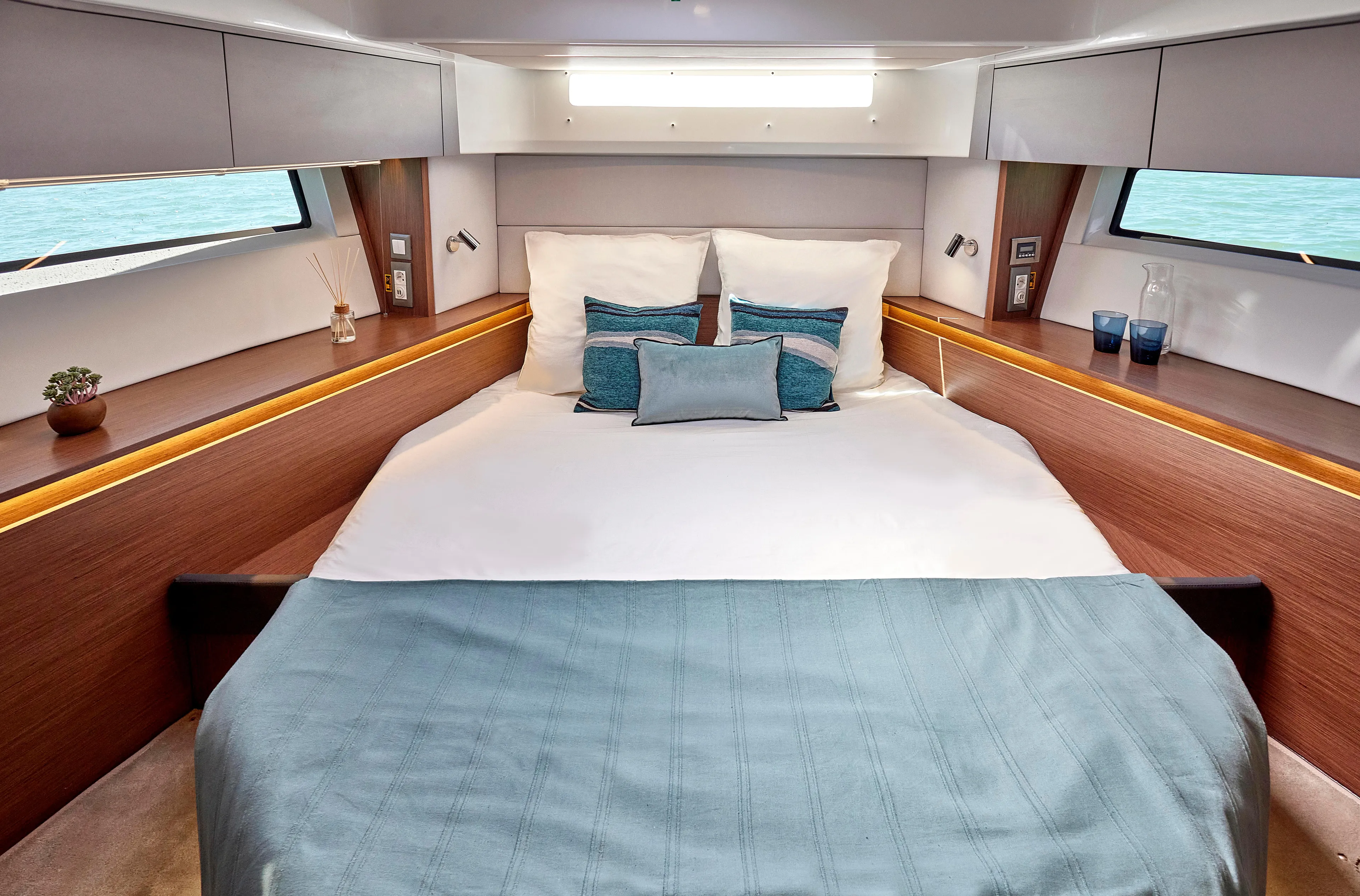  Yacht Photos Pics Luxurious cabin interior of 2026 Beneteau Antares 12 yacht with elegant bedding and modern design.