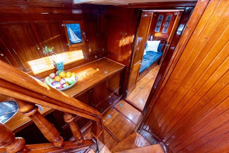  Yacht Photos Pics Luxurious wooden interior of 1912 Fred Shepherd 70 ft Bermudan yawl, featuring fruit bowl and cozy cabin.