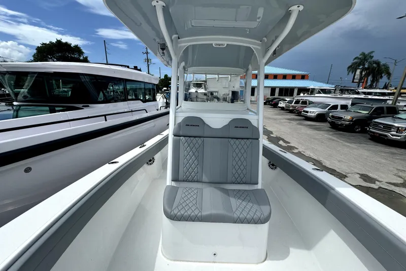  Yacht Photos Pics 2024 Bluewater 25t boat with sleek seating, docked at a marina under a cloudy sky.