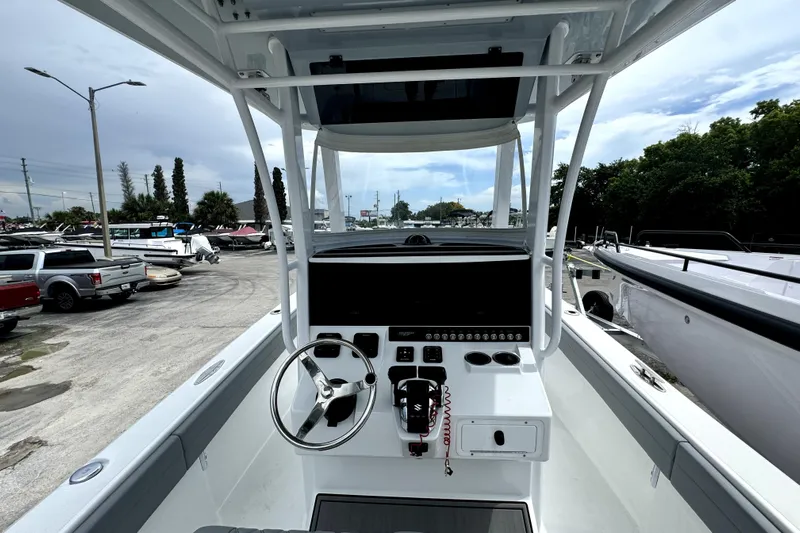  Yacht Photos Pics 2024 Bluewater 25t boat cockpit with steering wheel and control panel, parked in a marina.