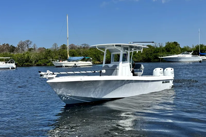  Yacht Photos Pics 2024 Bluewater 25t boat cruising on a calm river with lush greenery in the background.