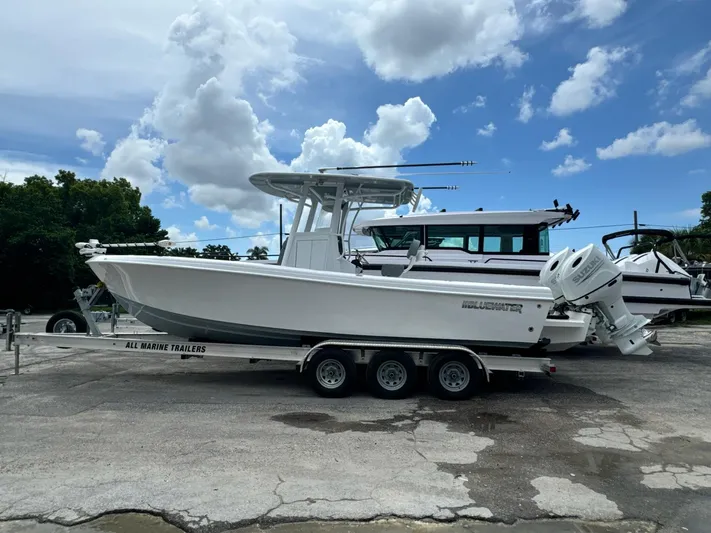  Yacht Photos Pics 2024 Bluewater Sportfishing 25T boat on trailer under a cloudy sky.