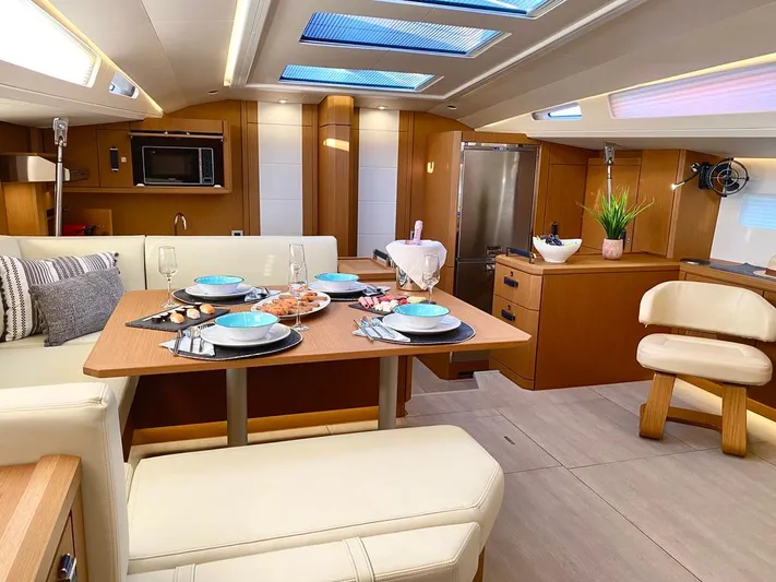 Euphoria Yacht Photos Pics Luxurious interior of 2021 Jeanneau 60 yacht with elegant dining setup and modern amenities.