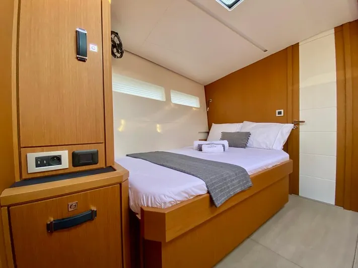 Euphoria Yacht Photos Pics Luxurious cabin interior of 2021 Jeanneau 60 yacht with cozy bed and modern wood finish.