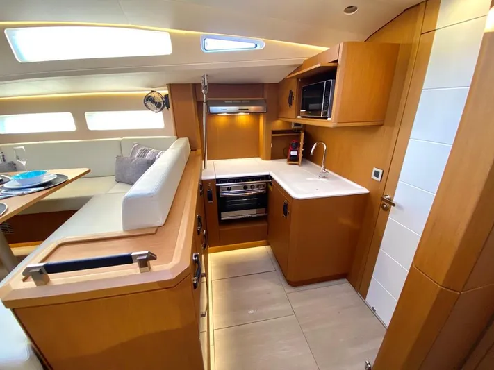 Euphoria Yacht Photos Pics Modern kitchen interior of 2021 Jeanneau 60 yacht with wood finish and appliances.