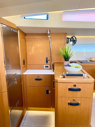 Euphoria Yacht Photos Pics Modern kitchen interior of 2021 Jeanneau 60 yacht with wooden cabinetry and sleek design.
