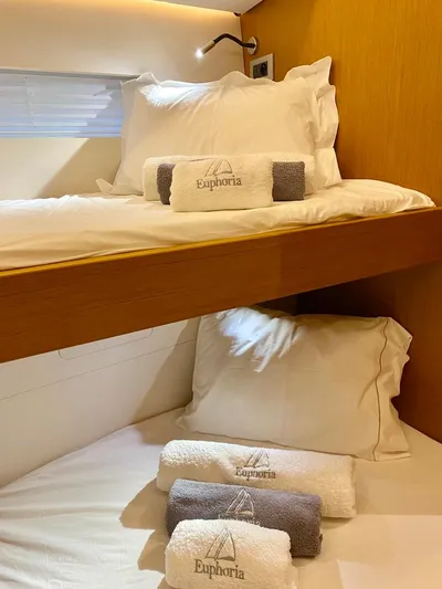 Euphoria Yacht Photos Pics Bunk beds with branded towels in a 2021 Jeanneau 60 yacht cabin.