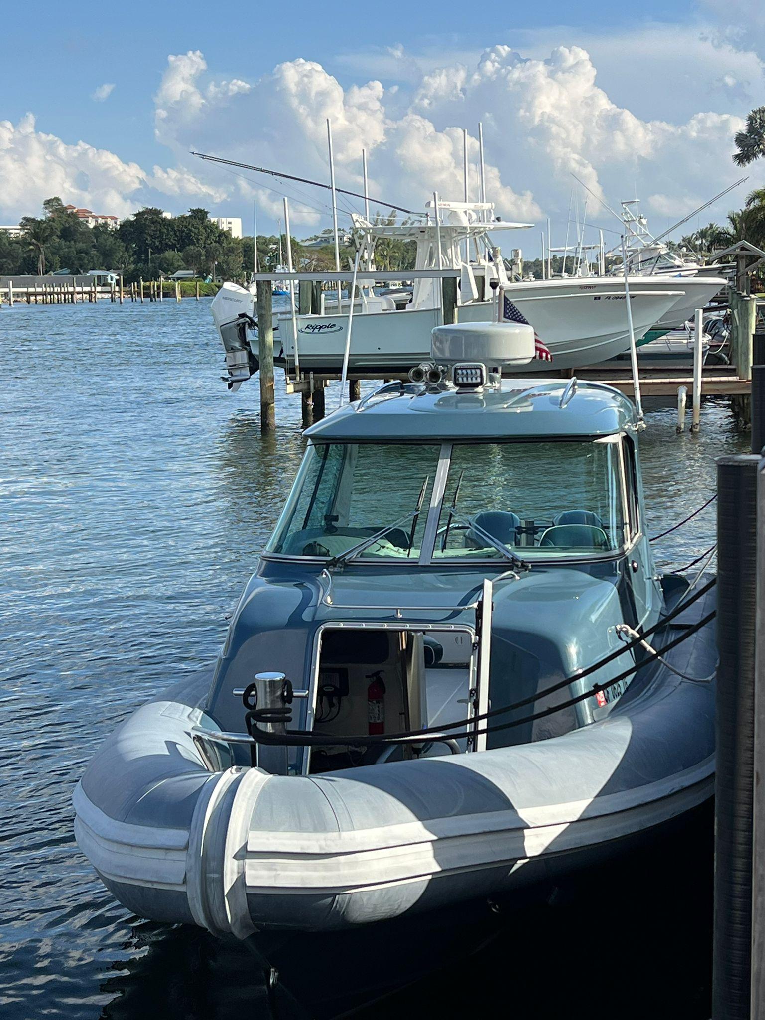 2000 Protector Targa 28 boat docked on a sunny day with fluffy clouds.
