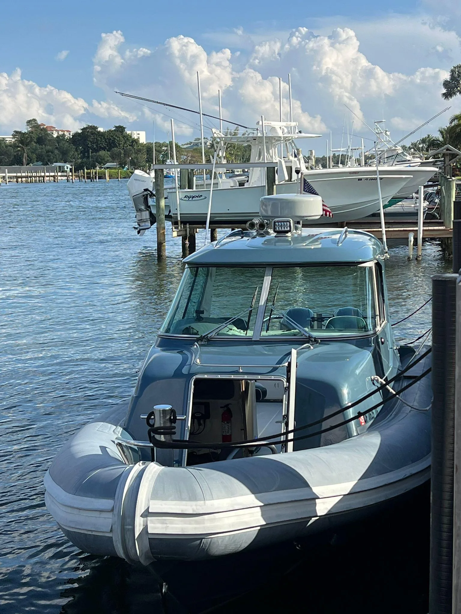 2000 Protector Targa 28 boat docked on a sunny day with fluffy clouds.