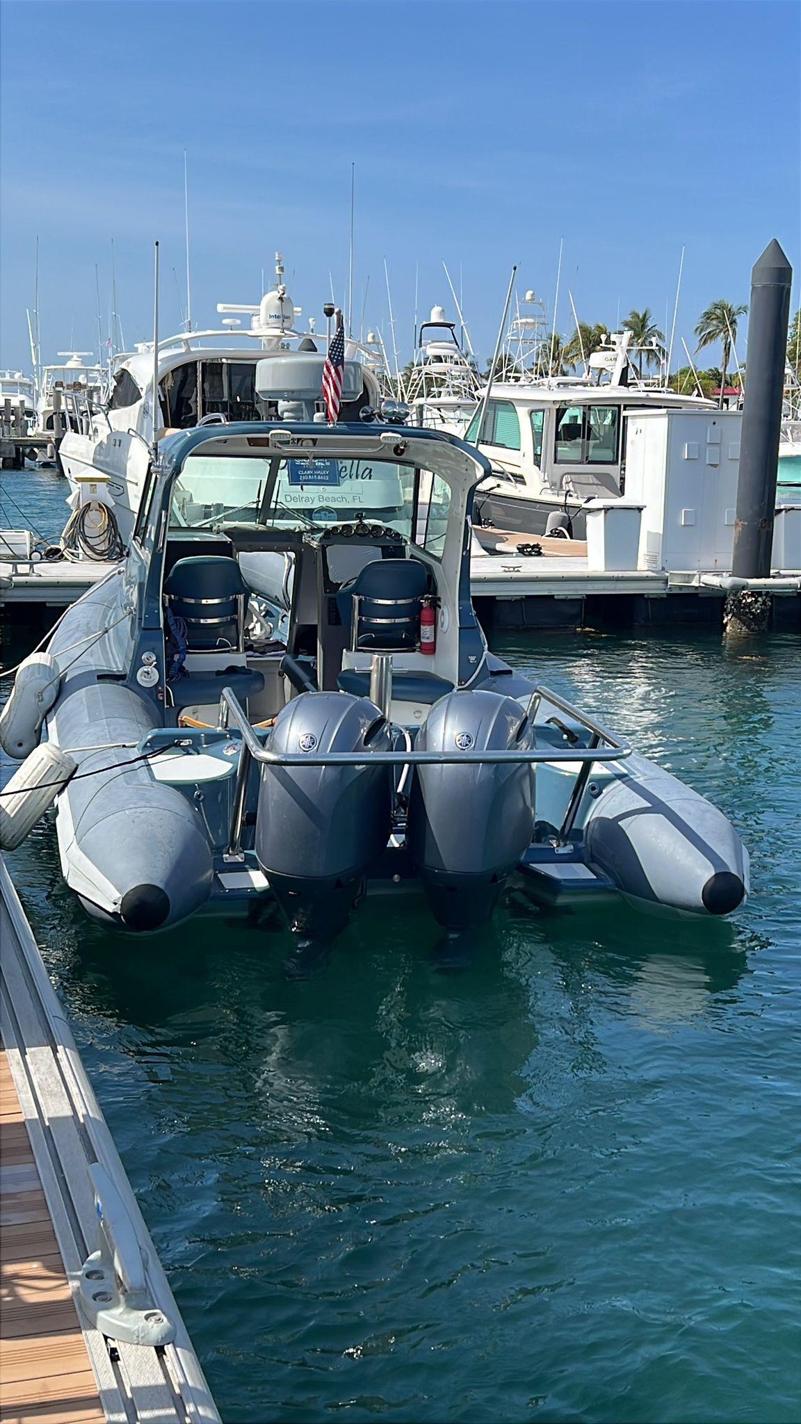 2000 Protector Targa 28 boat docked with dual outboard motors in a marina.