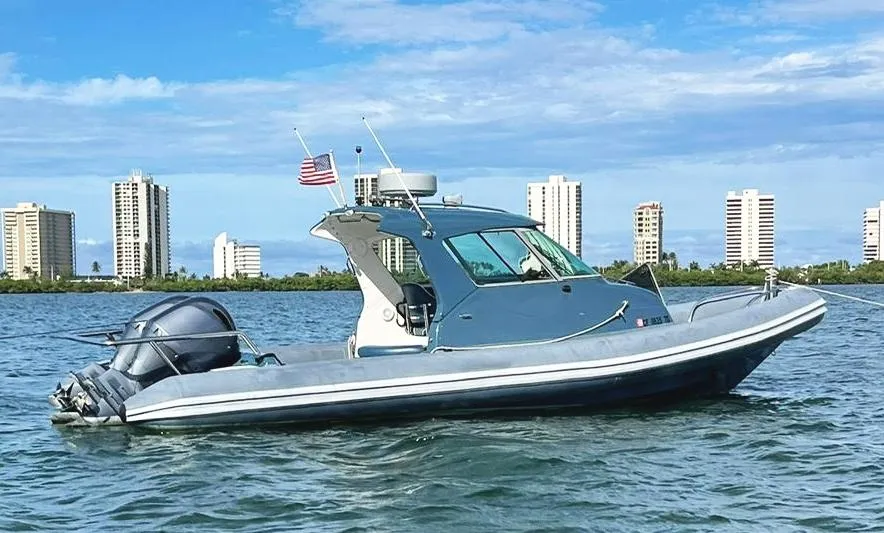 2000 Protector Targa 28 boat on water with city skyline in background.