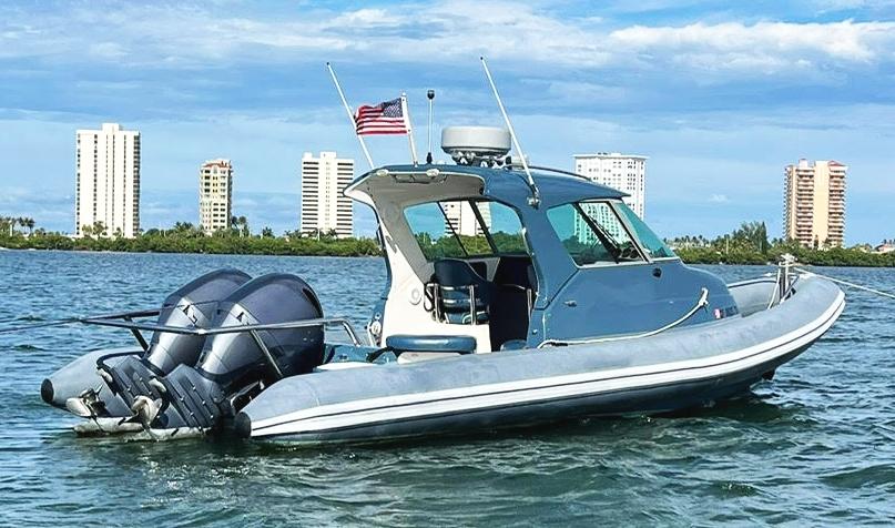 2000 Protector Targa 28 boat on water with city skyline in background.