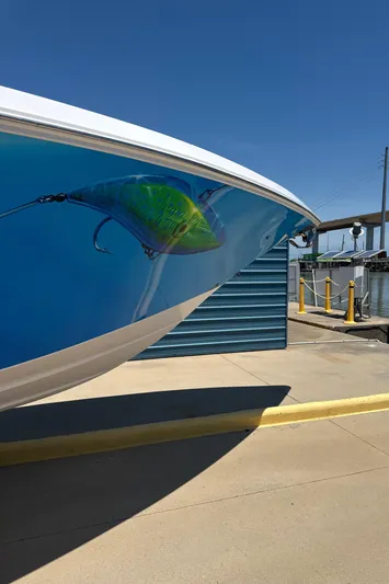  Yacht Photos Pics 2018 Fountain 38cc boat with vibrant fish artwork at a marina.