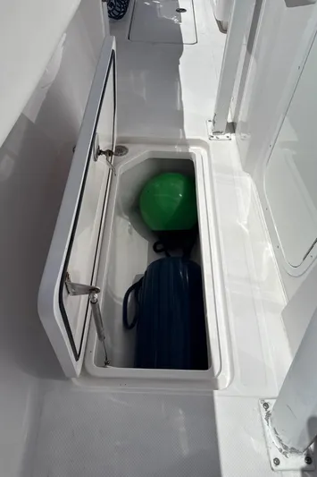  Yacht Photos Pics 2018 Fountain 38cc boat storage compartment with green and blue items inside.
