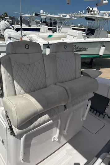  Yacht Photos Pics Luxury seating on a 2018 Fountain 38cc boat, docked with other vessels in the background.
